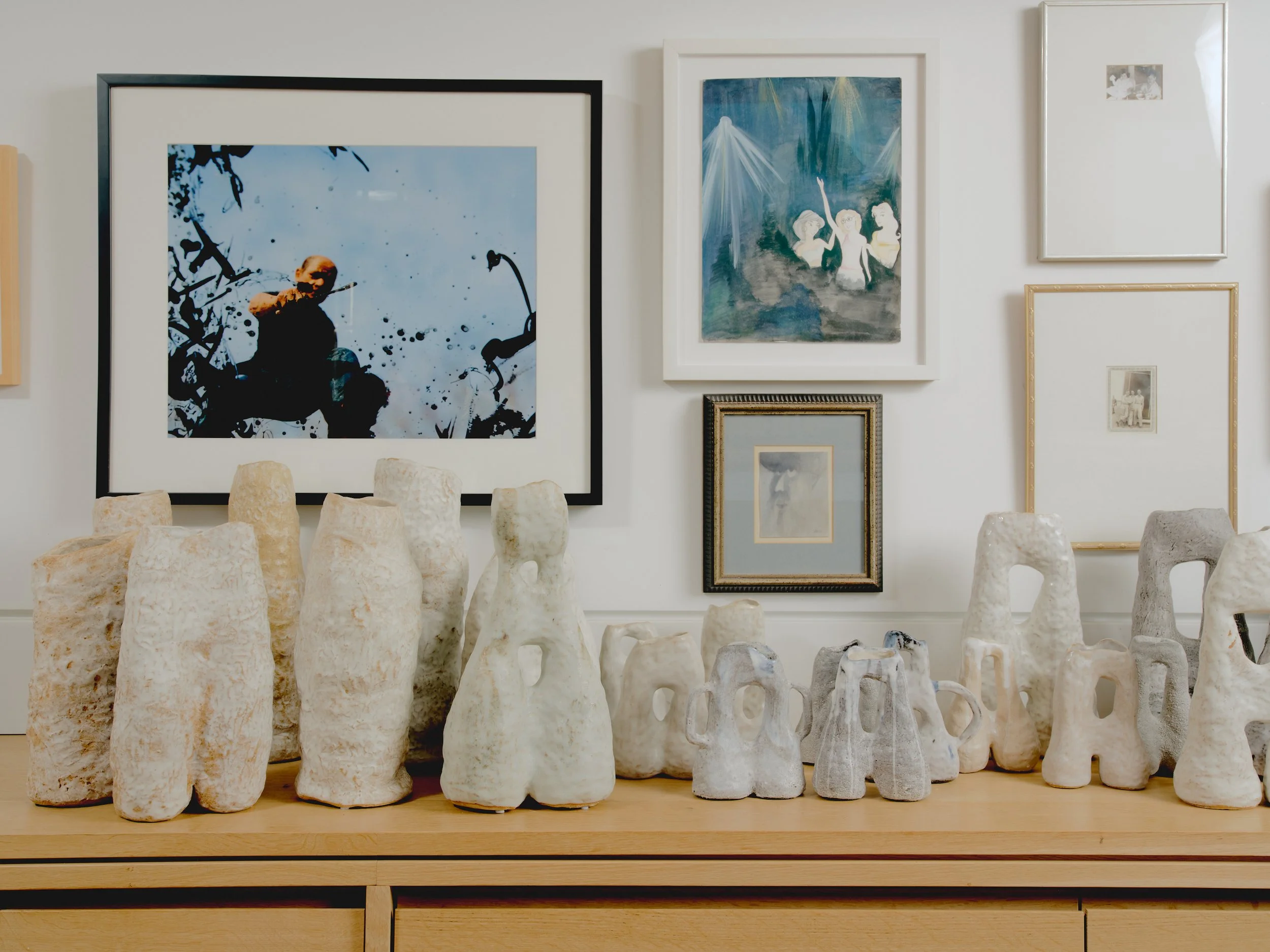 A collection of Wolf Rose Studio ceramic vessels lined up together